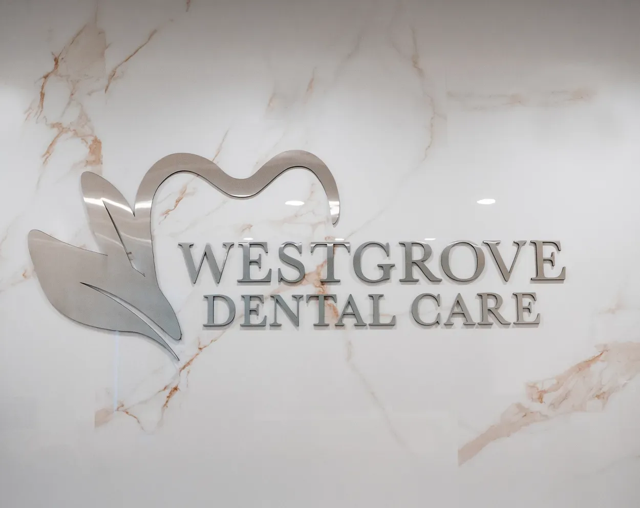 The Westgrove Dental Care logo on a marble wall behind the front desk